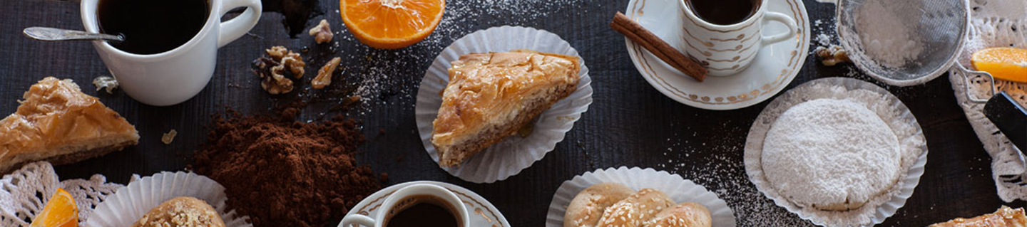 Baklava, powdered-sugar cookies and Greek coffee on a dark table