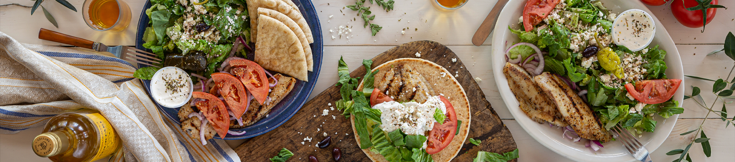 Greek plates with gyro, pita wraps and fresh-cut fries on a table
